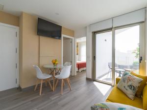 Una sala de estar con un sofá, una mesa y sillas. en Holiday Home in Telde near Playa de Melenara, en Telde