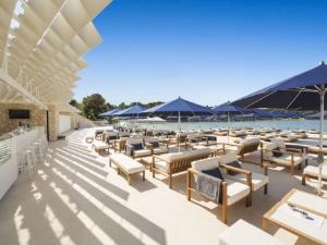 a patio with chairs and tables and blue umbrellas at Villa in minj with swimming pool in Žminj