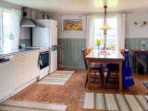 a kitchen with a table and chairs and a table and a kitchen with a table at 6 person holiday home in mellerud in Mellerud