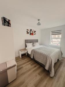 a white bedroom with a bed and a window at Modern Stay - Walk to Everything 2 in Ipswich