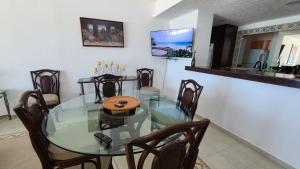 een eetkamer met een glazen tafel en stoelen bij Beach Patio Paradise in Cancun