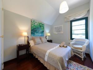 ein Schlafzimmer mit einem Bett und einem Stuhl und einem Fenster in der Unterkunft House in Santa Brígida with Sea & Mountain Views in Santa Brígida