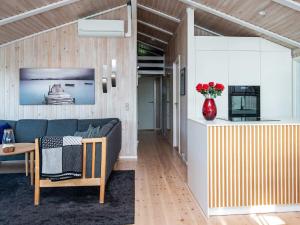 a living room with a couch and a vase of flowers at 4 star holiday home in Juelsminde in Sønderby
