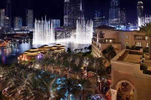杜拜的住宿－迪拜市中心皇宮酒店，享有带喷泉的夜间城市景观