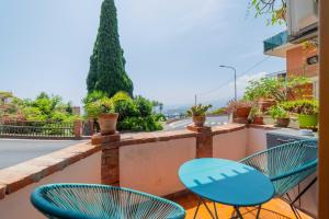 a balcony with two blue chairs and a street at A Me Casa - Taormina in Taormina