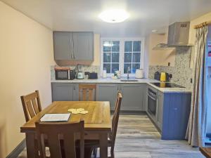 a kitchen with a wooden table and a dining room at Snowdon - Uk6627 in Pen-y-groes
