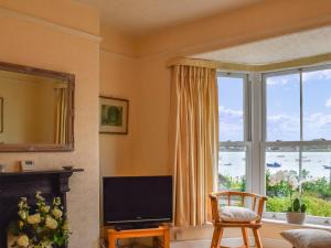 un soggiorno con TV e una grande finestra di Waterside Cottage a Saltash