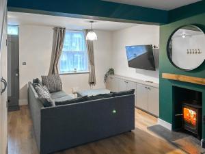 a living room with a couch and a fireplace at Willow Cottage in Beverley