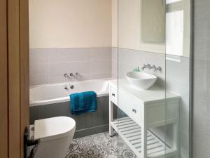 a bathroom with a tub and a sink and a toilet at Willow Cottage in Beverley