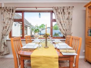 a dining room with a table with a yellow table cloth at Black Rock Cottage in Culbokie