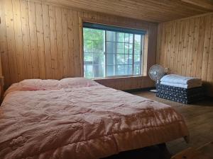 a bedroom with a large bed and a window at Haeoreum Pension in Ulleung