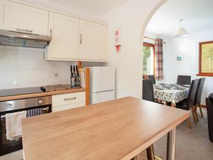 cocina con mesa de madera y cocina con comedor en Bidean Cottage - Uk41933, en Glencoe