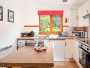 cocina con mesa de madera y fregadero en Bidean Cottage - Uk41933, en Glencoe