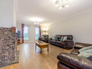 a living room with leather furniture and a stone fireplace at Iora Rua-Uk40006 in Gartmore