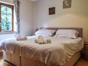 ein Schlafzimmer mit einem großen Bett mit Handtüchern darauf in der Unterkunft Lily Cottage - Uk40101 in Dunvant