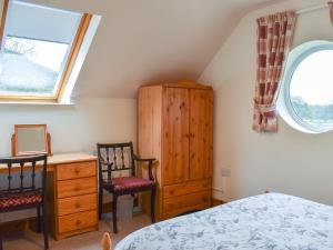 a bedroom with a bed and a dresser and a window at Ty Mawr 1 - Uk36545 in Nantlle +4 photos