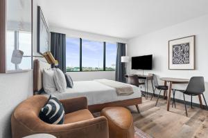 um quarto de hotel com uma cama, uma mesa e cadeiras em Lodgeur Upper Kirby, Houston - Close to Greenway Plaza, Galleria, Montrose em Houston