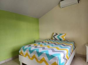 a bedroom with a bed with a colorful comforter at Villa Janel in Punta Rucia