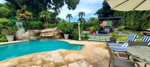 a swimming pool with a table and chairs and an umbrella at Private House in Playa Coronado in Nueva Gorgona