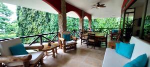 a room with a balcony with chairs and a table at Private House in Playa Coronado in Nueva Gorgona