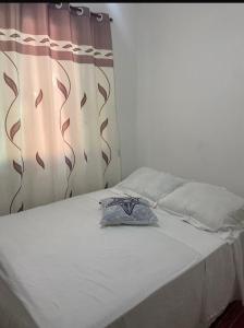 Ένα ή περισσότερα κρεβάτια σε δωμάτιο στο Suites e Quartos Em frente a Praia Grande -Na orla Flavia Alessandra +1 φωτογραφίες