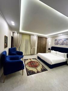 a bedroom with a bed and a blue chair at Rashha Suites Jhika Gali Murree in Murree