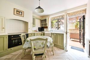 a kitchen with a table and chairs and a window at bloomrooms@Knightsbridge/HydePark in London