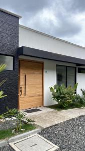 a house with a wooden door on the side of it at Casa con Terraza y Vista Espectacular a la Naturaleza in Dosquebradas