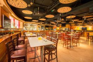 un ristorante con tavoli e sedie e un bar di Horizon Manor Hotel a Doha