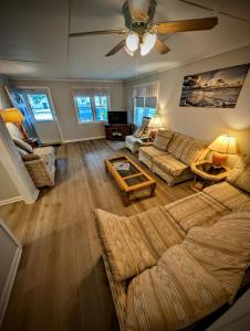 a living room with a couch and a ceiling fan at Ocean Breeze Retreat in Beach Haven