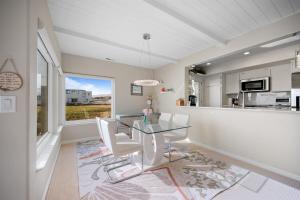 a dining room with a glass table and white chairs at Blue Haven-Oceanfront Stay Near Cambria & Beaches in San Simeon