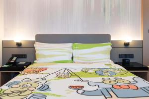 a bed with a hello kitty comforter on it at Holiday Inn Shanghai Nanjing Road by IHG in Shanghai