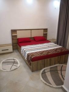 a bedroom with a large wooden bed with red pillows at Le nid d'Azur tipaza in Tipaza