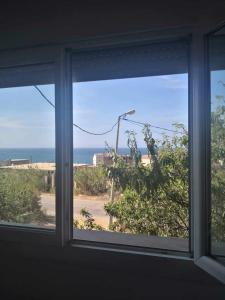 a window in a room with a view of the ocean at Le nid d'Azur tipaza in Tipaza