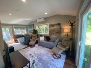 a living room with a couch and chairs and a table at Cozy en suite with high ceilings in Framingham