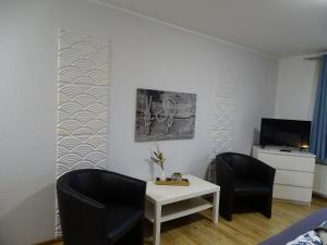 a living room with two chairs and a table at Fewo Seeanker in Friedrichskoog