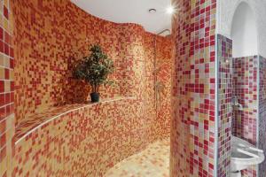 a tiled bathroom with a potted plant in it at Fewo Seeanker in Friedrichskoog +17 photos