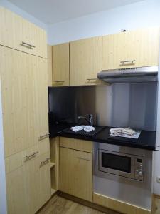 a kitchen with wooden cabinets and a stove top oven at Fewo-Seegras in Friedrichskoog +18 photos