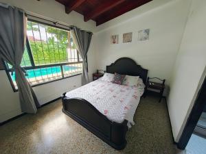 GuayacanaにあるCasa con piscina privada en via flandes espinalのベッドと大きな窓のある寝室 +43枚の写真