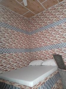 a small room with a bed in a brick wall at Sunset travelers lodge and restaurant 