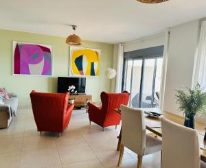 a living room with red chairs and a table at Villa Harmonia in Egina