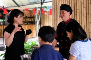 a man and a woman standing in a kitchen with children at Halise Home and Retreat Ninh Binh in Ninh Binh