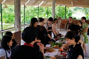 a group of people standing around a table with food at Halise Home and Retreat Ninh Binh in Ninh Binh