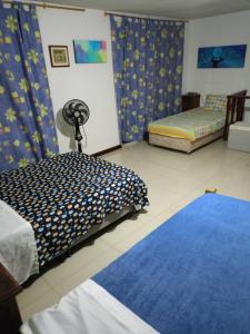 佩雷拉HABITACION CERCA AL AEROPUERTO的一间带两张床的卧室和蓝色地毯