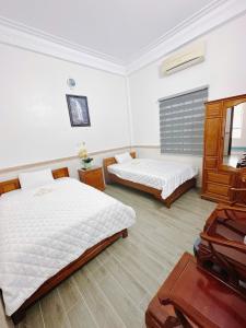 a bedroom with two beds and a piano in it at Bảo Yến HOTEL in Bản Khe Rạn