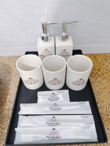 a tray with three cups and toothbrushes on a counter at Bảo Yến HOTEL in Bản Khe Rạn