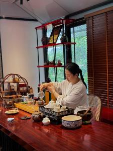 a woman sitting at a table preparing food at Halise Sanctuary Ninh Binh in Ninh Binh