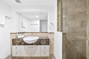 a bathroom with a sink and a shower at Zanzibar 404, Sensational 2 Bedroom Oceanview Apartment in Mooloolaba