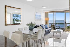 a living room with a table and a couch at Zanzibar 404, Sensational 2 Bedroom Oceanview Apartment in Mooloolaba