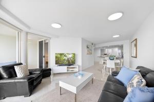 a living room with a couch and a table at Zanzibar 404, Sensational 2 Bedroom Oceanview Apartment in Mooloolaba